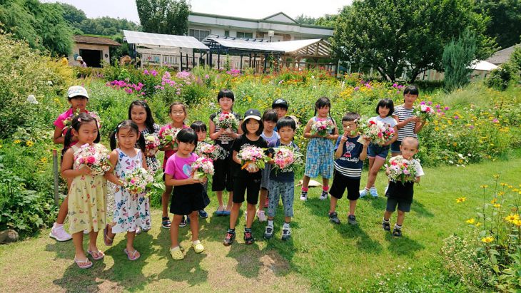 自分で作ったフラワーアレンジメントを抱える小学生たち
